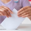 Manos introduciendo el voto en urna